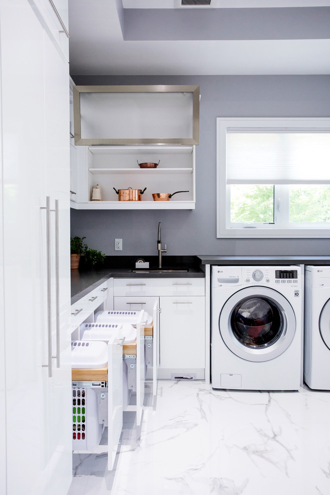 Photo of a large modern l-shaped dedicated laundry room in Toronto with an undermount sink, flat-panel cabinets, white cabinets, quartz benchtops, grey walls, marble floors, a side-by-side washer and dryer, white floor and grey benchtop.