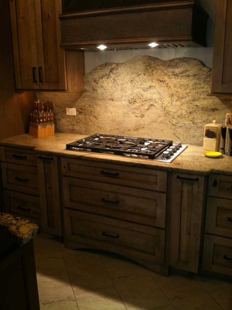 Inspiration for a large rustic l-shaped porcelain tile open concept kitchen remodel in Chicago with a farmhouse sink, recessed-panel cabinets, medium tone wood cabinets, granite countertops, beige backsplash, stone slab backsplash, stainless steel appliances and an island