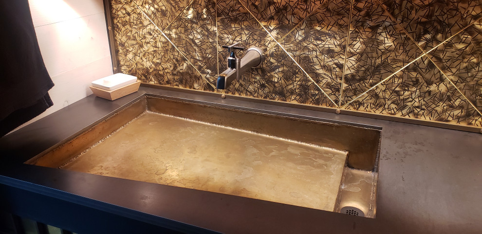 Industriell inredning av ett litet brun brunt badrum med dusch, med släta luckor, skåp i mörkt trä, gul kakel, kakel i metall, vita väggar, ljust trägolv, bänkskiva i betong och vitt golv