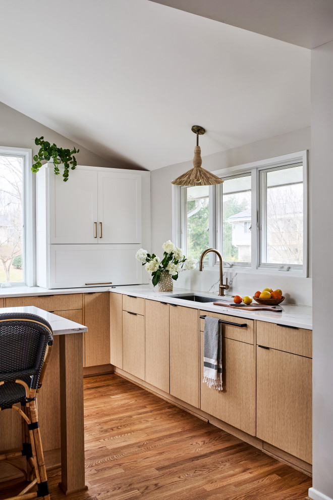 Große Mid-Century Wohnküche in L-Form mit Quarzwerkstein-Arbeitsplatte, Küchenrückwand in Weiß, braunem Holzboden, Kücheninsel und weißer Arbeitsplatte in Washington, D.C.