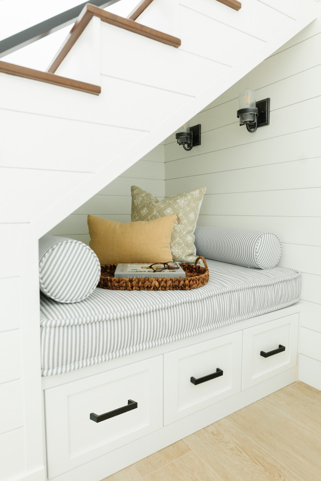 This is an example of a large beach style wood metal railing staircase in Miami with painted wood risers and tongue and groove walls.