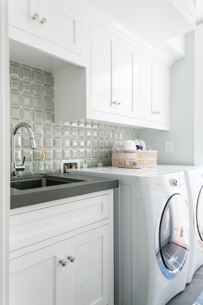 Design ideas for a mid-sized beach style dedicated laundry room in Orange County with an undermount sink, shaker cabinets, white cabinets, concrete benchtops, porcelain floors, a side-by-side washer and dryer, grey floor, grey benchtop and grey walls.