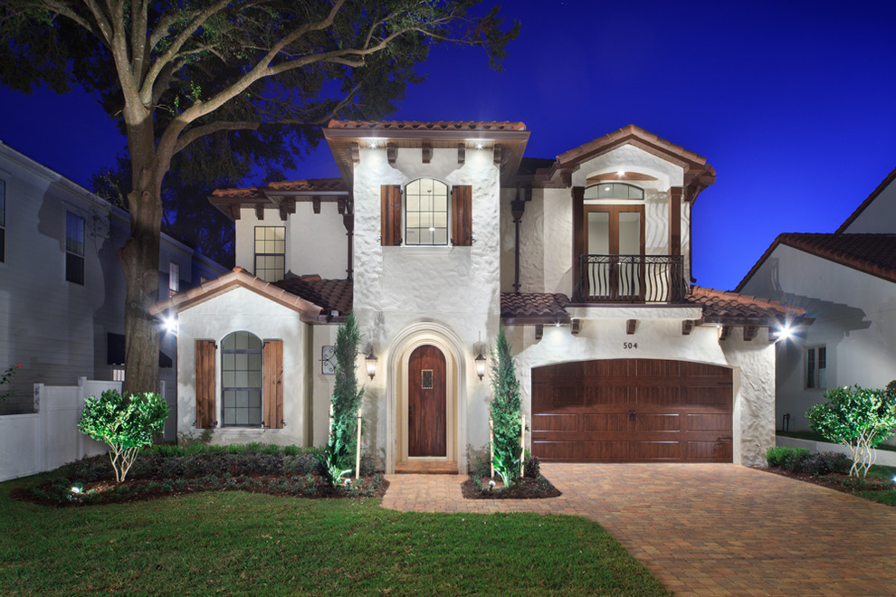 This is an example of a mid-sized mediterranean two-storey stucco white exterior in Orlando.
