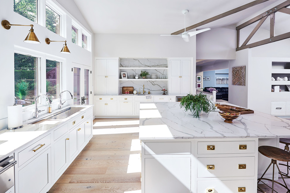 Inspiration for a transitional l-shaped light wood floor and beige floor kitchen remodel in New York with shaker cabinets, white cabinets and an island