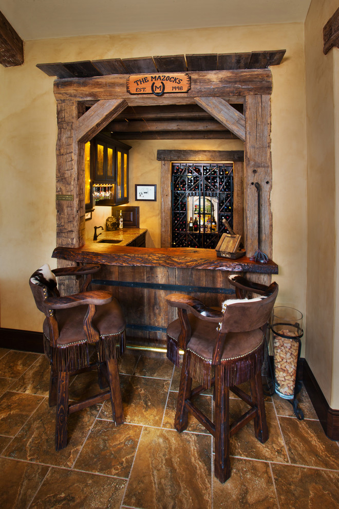 Tuscan l-shaped brown floor seated home bar photo in Austin with wood countertops