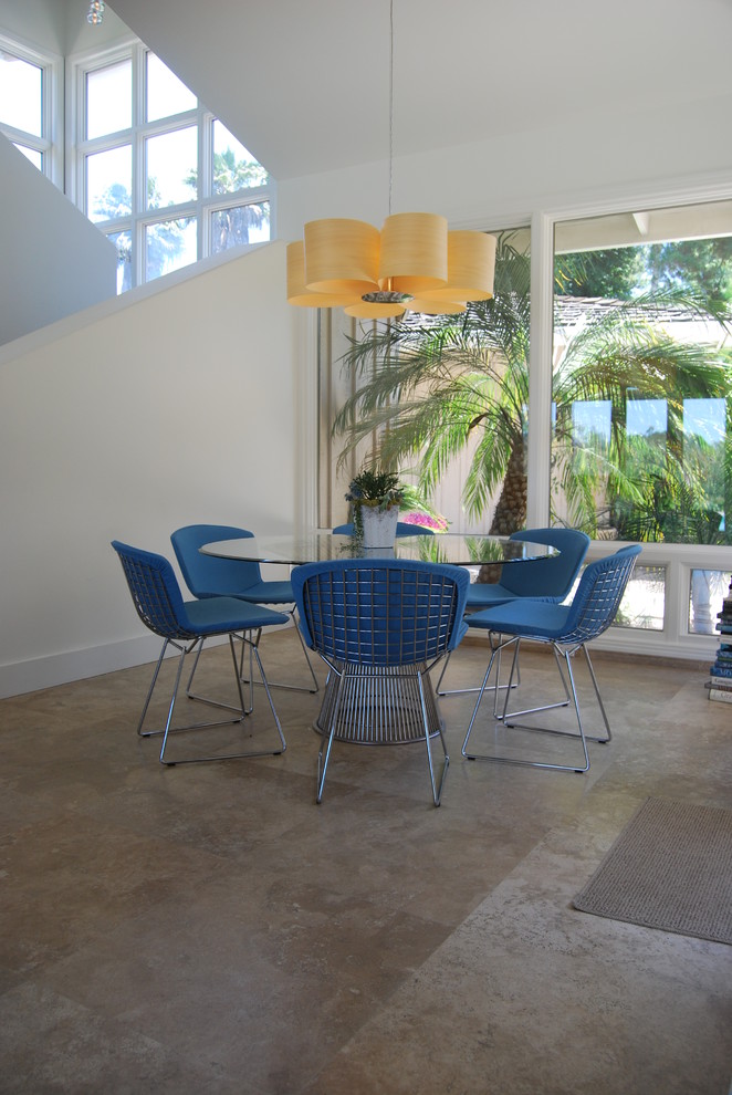 This is an example of a contemporary dining room in San Diego with concrete floors and white walls.