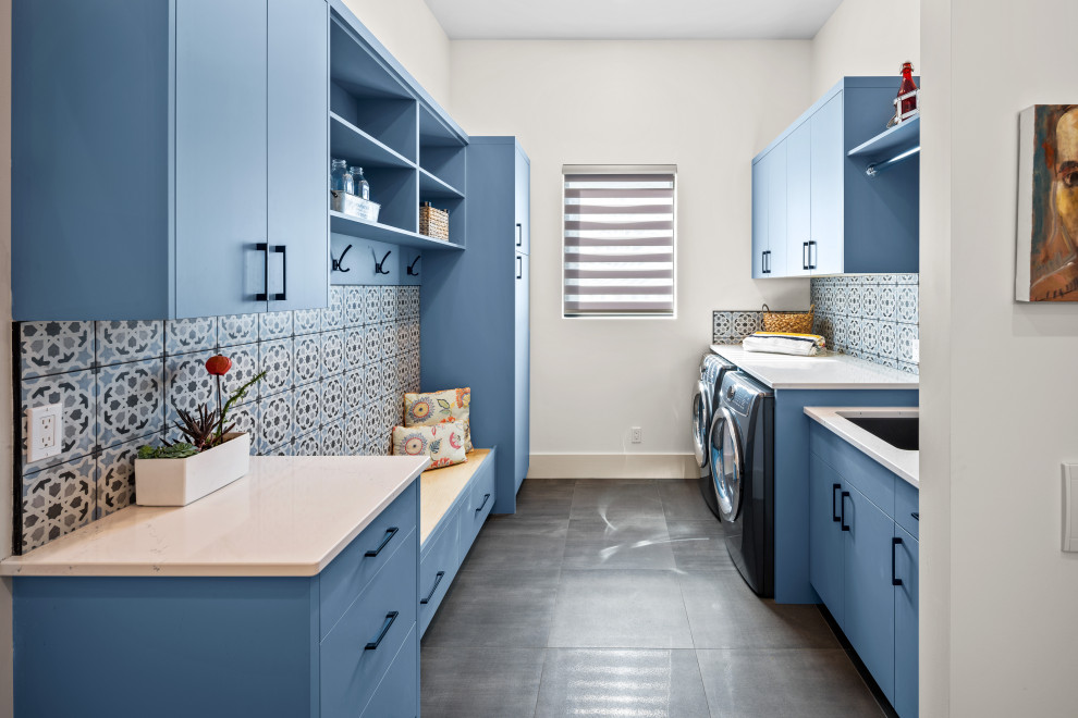 Inspiration for a contemporary galley utility room in Vancouver with an undermount sink, flat-panel cabinets, blue cabinets, quartz benchtops, blue splashback, ceramic splashback, white walls, ceramic floors, a side-by-side washer and dryer, grey floor and yellow benchtop.