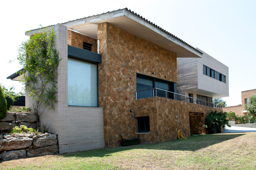 This is an example of a large contemporary three-storey brown house exterior in Other with stone veneer, a shed roof and a tile roof.