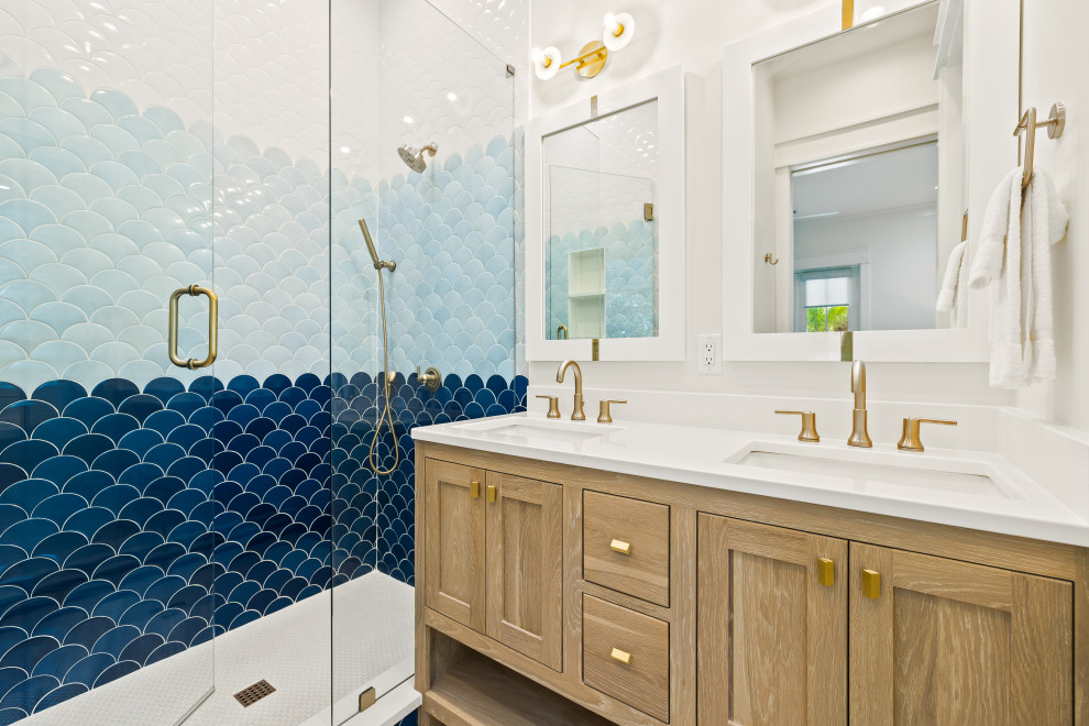 Пример оригинального дизайна: ванная комната среднего размера в морском стиле с фасадами в стиле шейкер, светлыми деревянными фасадами, синей плиткой, белыми стенами, полом из керамогранита, врезной раковиной, столешницей из кварцита, белым полом, душем с распашными дверями, белой столешницей, тумбой под две раковины и встроенной тумбой