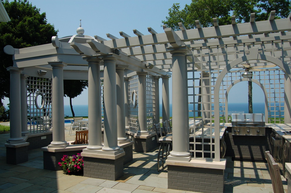 This is an example of a traditional patio in Grand Rapids with an outdoor kitchen and a pergola.