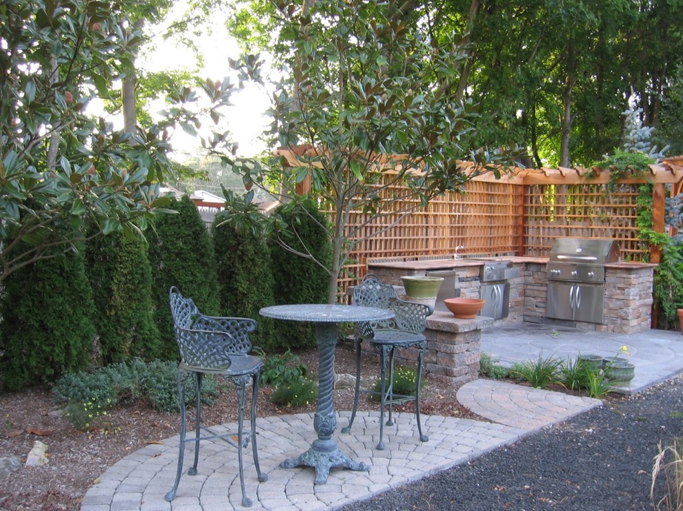 Traditional backyard patio in New York with an outdoor kitchen, natural stone pavers and a gazebo/cabana.