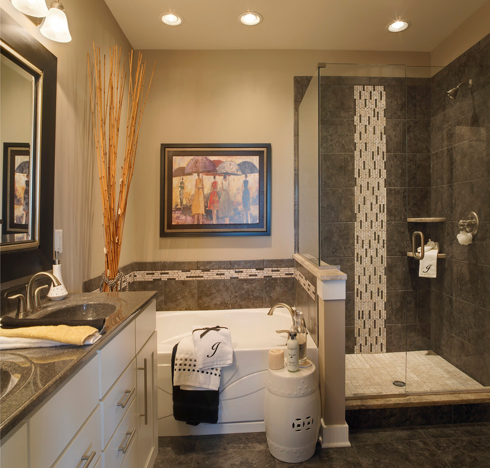 Example of a mid-sized transitional master gray tile and ceramic tile ceramic tile drop-in bathtub design with shaker cabinets, white cabinets, marble countertops, beige walls, an integrated sink and a one-piece toilet