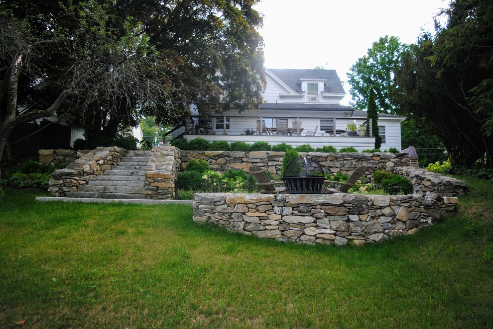 Inspiration for a mid-sized traditional partial sun backyard stone formal garden for summer.