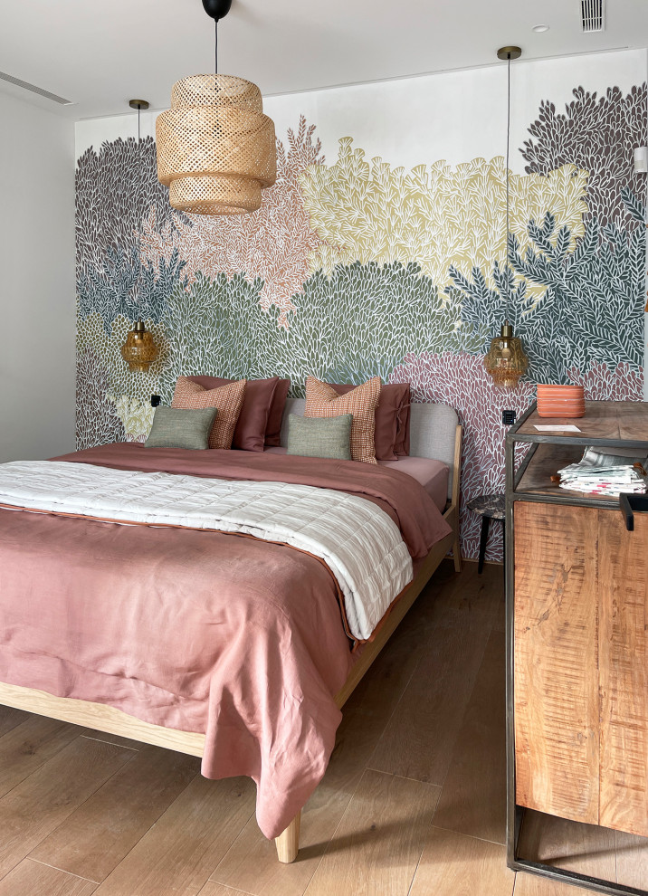 Ejemplo de habitación de invitados beige y rosa tropical pequeña con paredes verdes, suelo de madera en tonos medios, suelo marrón y papel pintado