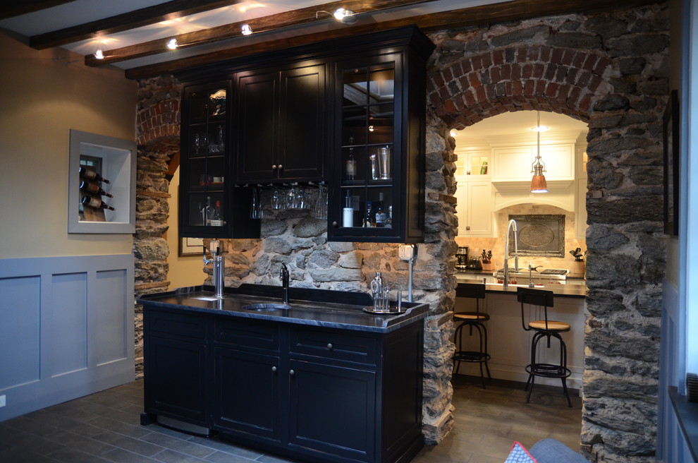 Large transitional single-wall wet bar in Philadelphia with an undermount sink, shaker cabinets, black cabinets, marble benchtops, slate floors, stone tile splashback and brown floor.