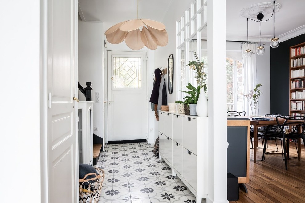 This is an example of a small contemporary entry hall in Paris with white walls, a single front door, a white front door and multi-coloured floor.