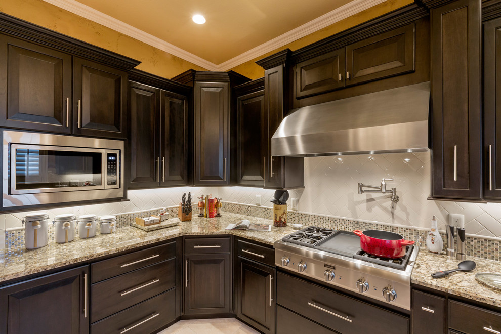 Traditional kitchen in Dallas with a drop-in sink, granite benchtops and stainless steel appliances.