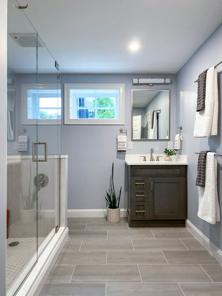 Example of a transitional white tile and ceramic tile porcelain tile, gray floor and single-sink corner shower design in Boston with shaker cabinets, gray cabinets, a one-piece toilet, gray walls, an undermount sink, quartz countertops, a hinged shower door, white countertops and a built-in vanity