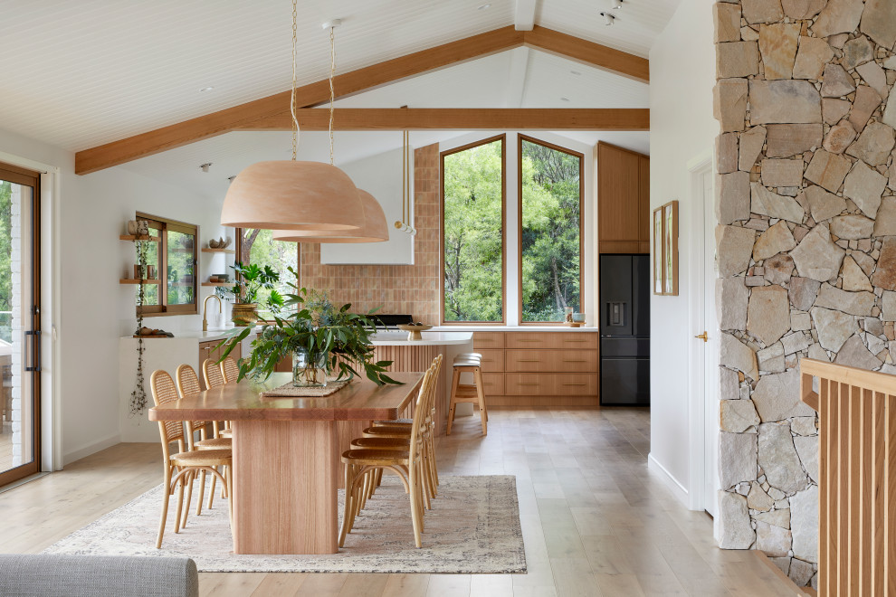 Imagen de comedor moderno abierto con paredes blancas, suelo de madera en tonos medios, suelo marrón y vigas vistas