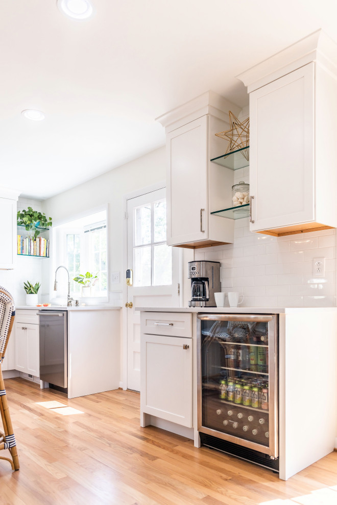 Eat-in kitchen - mid-sized transitional l-shaped light wood floor and brown floor eat-in kitchen idea in Baltimore with an undermount sink, shaker cabinets, white cabinets, quartz countertops, white backsplash, marble backsplash, stainless steel appliances, an island and white countertops