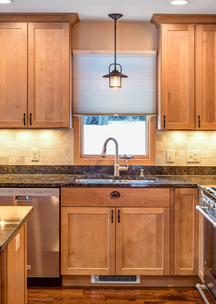 Mid-sized traditional l-shaped eat-in kitchen in Minneapolis with an undermount sink, shaker cabinets, medium wood cabinets, granite benchtops, beige splashback, stone tile splashback, stainless steel appliances, medium hardwood floors and with island.