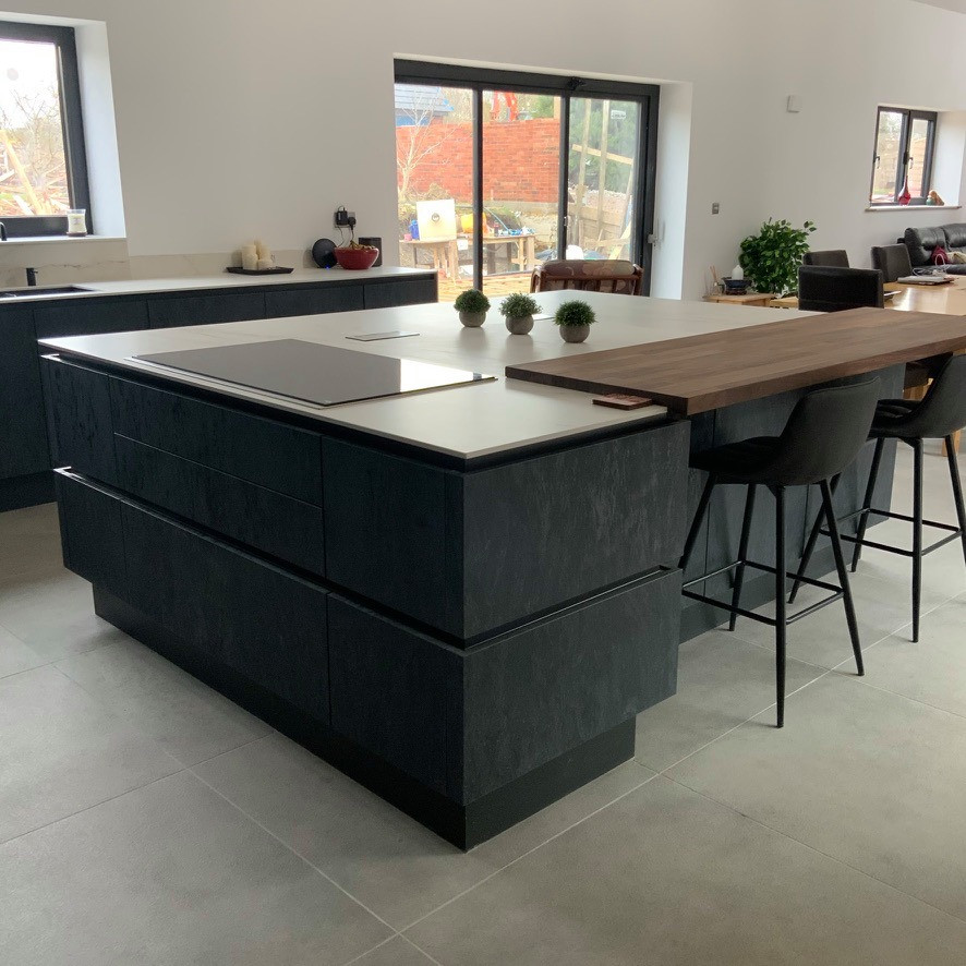 Design ideas for a large contemporary l-shaped kitchen in Buckinghamshire with flat-panel cabinets, grey cabinets, panelled appliances, with island and white benchtop.