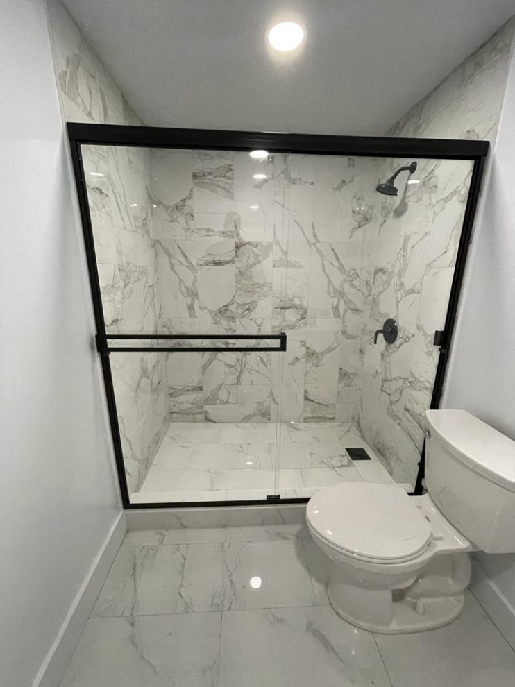 Photo of a small contemporary bathroom in Salt Lake City with glass-front cabinets, porcelain floors, granite benchtops, a sliding shower screen and a single vanity.
