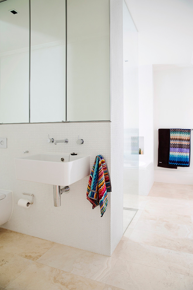This is an example of a contemporary bathroom in Sydney with a wall-mount sink, a drop-in tub, a curbless shower, white tile and white walls.