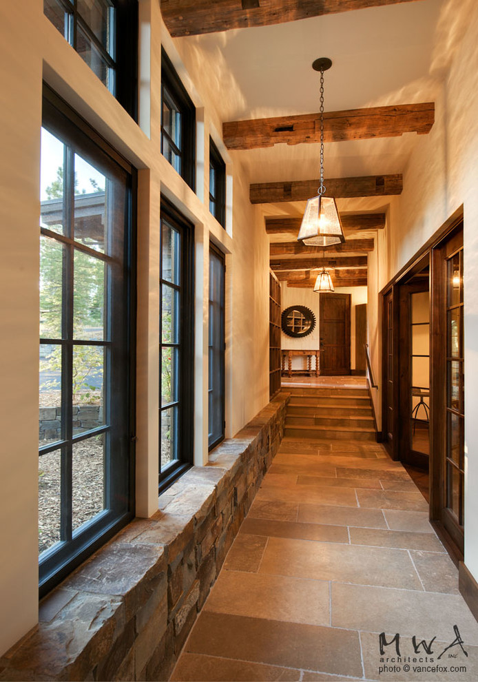Mid-sized traditional hallway in Other with beige walls, limestone floors and grey floor.