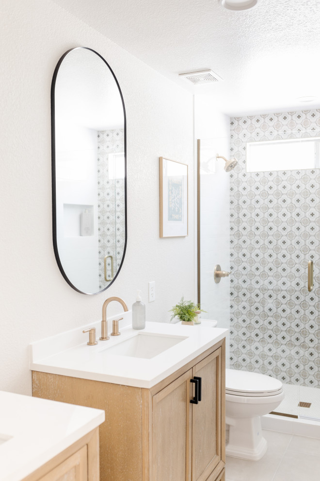 Exemple d'une petite salle de bain principale bord de mer en bois clair avec un placard à porte shaker, un carrelage multicolore, des carreaux de céramique, un sol en carrelage de porcelaine, un sol gris, un plan de toilette blanc, meuble simple vasque et meuble-lavabo sur pied.