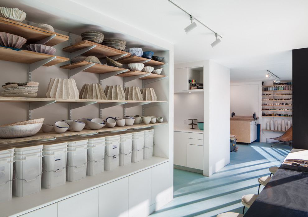 Стильный дизайн: домашняя мастерская в современном стиле с белыми стенами, бетонным полом и синим полом - последний тренд