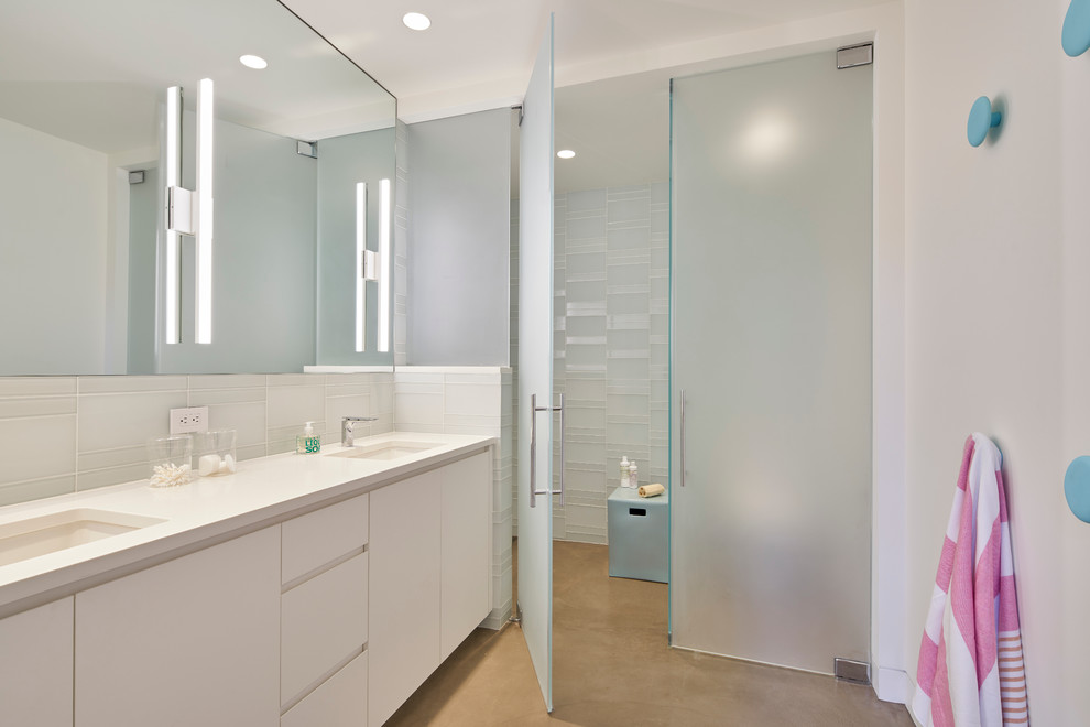 Design ideas for a large contemporary kids bathroom in San Francisco with flat-panel cabinets, white cabinets, a curbless shower, white tile, glass tile, white walls, concrete floors, an undermount sink, engineered quartz benchtops, a two-piece toilet and a hinged shower door.