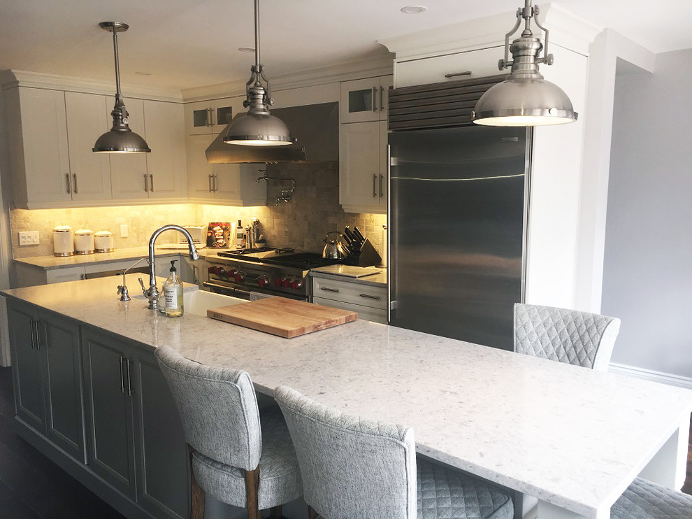 Transitional l-shaped brown floor eat-in kitchen photo with a farmhouse sink, white cabinets, quartz countertops, stainless steel appliances, an island and white countertops