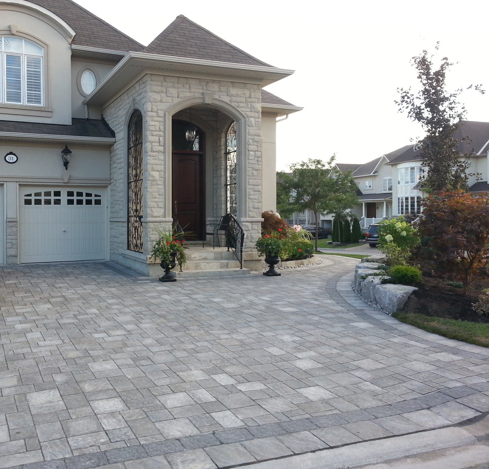 Traditional front yard driveway in Toronto with brick pavers.