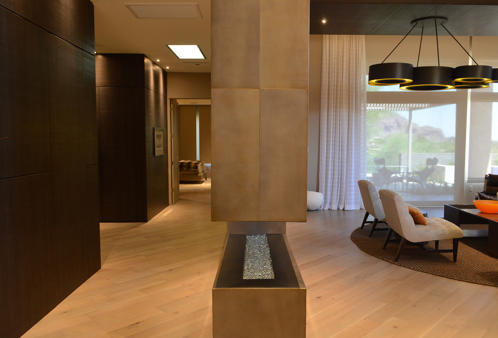 Living room - mid-sized modern enclosed light wood floor and brown floor living room idea in Phoenix with beige walls and a two-sided fireplace