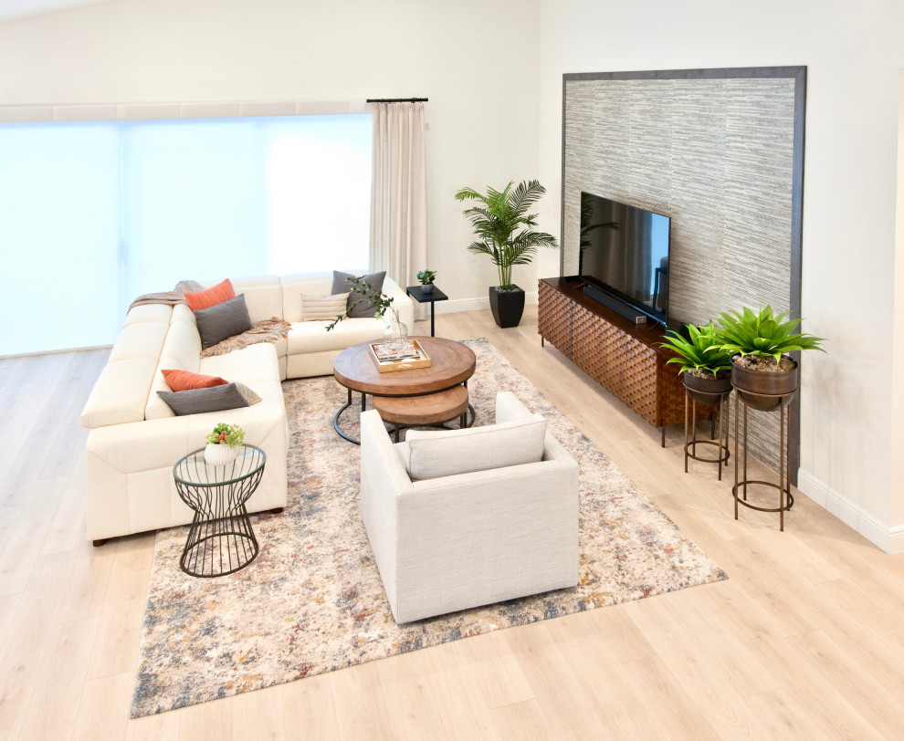 Imagen de salón abierto y blanco y madera marinero grande con paredes blancas, suelo laminado, televisor independiente, suelo beige, piedra y alfombra