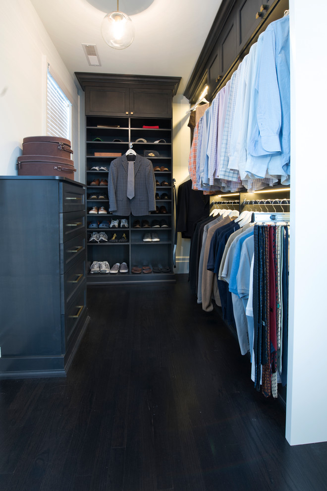 This is an example of a large transitional men's walk-in wardrobe in Chicago with recessed-panel cabinets, white cabinets and dark hardwood floors.