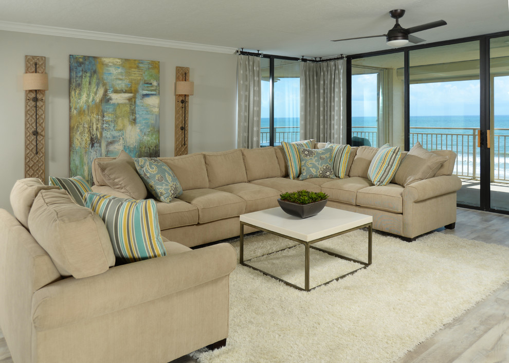 Photo of a large beach style open concept living room in Orlando with grey walls, light hardwood floors, white floor and a wall-mounted tv.