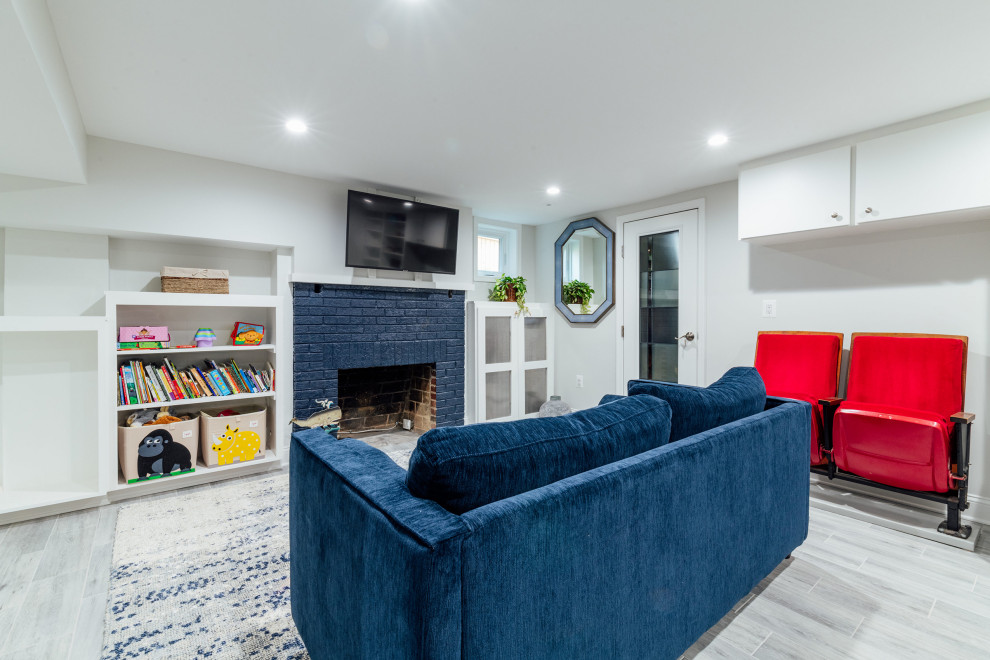 Inspiration for a small classic walk-out basement in DC Metro with grey walls, vinyl flooring, a standard fireplace and a brick fireplace surround.