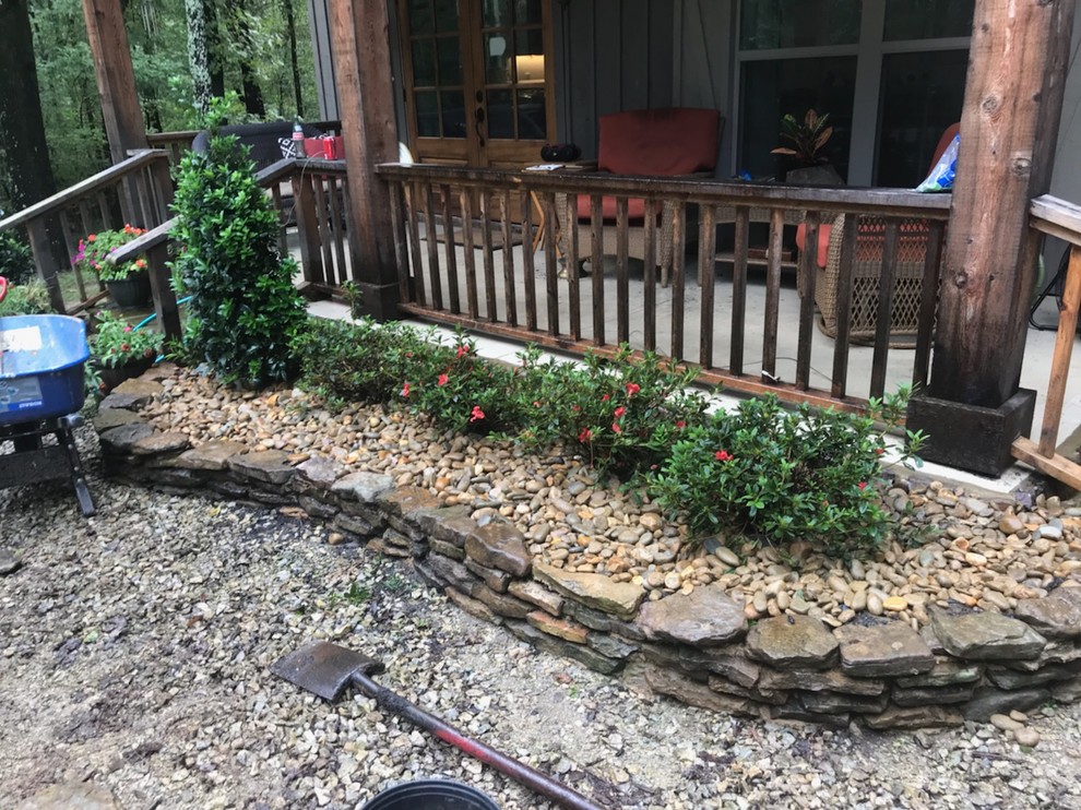 Photo of a rustic front yard stone landscaping.