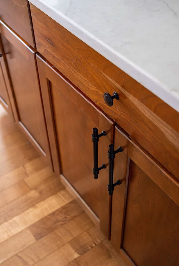 Example of a large transitional u-shaped medium tone wood floor and brown floor eat-in kitchen design in Minneapolis with a single-bowl sink, shaker cabinets, white cabinets, quartz countertops, white backsplash, porcelain backsplash, stainless steel appliances, an island and white countertops