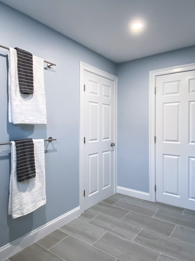 Corner shower - transitional white tile and ceramic tile porcelain tile, gray floor and single-sink corner shower idea in Boston with shaker cabinets, gray cabinets, a one-piece toilet, gray walls, an undermount sink, quartz countertops, a hinged shower door, white countertops and a built-in vanity