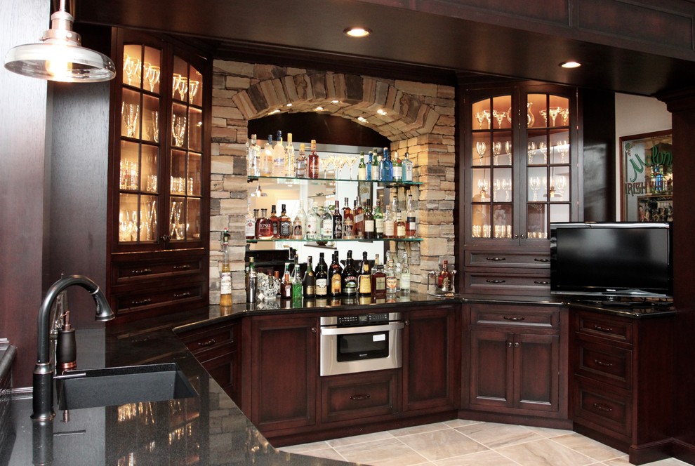 Inspiration for a large traditional wet bar with an undermount sink, recessed-panel cabinets, dark wood cabinets, granite benchtops, brown splashback and porcelain floors.