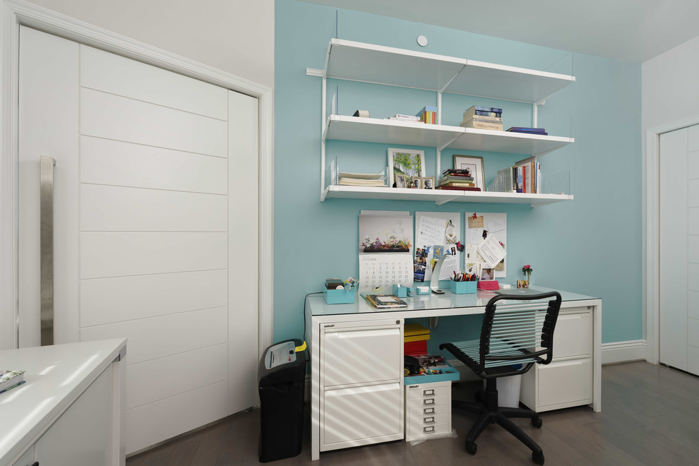 Trendy freestanding desk dark wood floor and brown floor study room photo in DC Metro with blue walls and no fireplace
