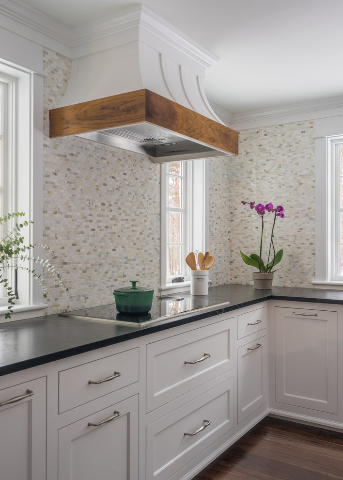 Example of a mid-sized transitional l-shaped dark wood floor and brown floor enclosed kitchen design in Boston with an integrated sink, white cabinets, soapstone countertops, multicolored backsplash, porcelain backsplash, stainless steel appliances, an island and shaker cabinets