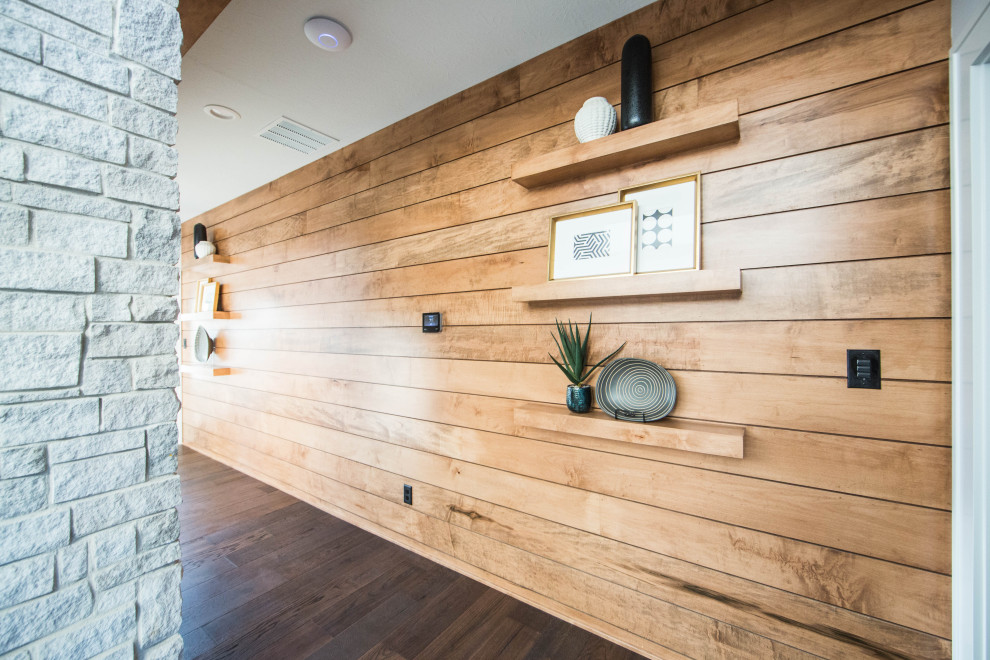 Idee per un ampio ingresso o corridoio minimalista con pareti marroni, pavimento in legno massello medio, pavimento marrone e pareti in perlinato