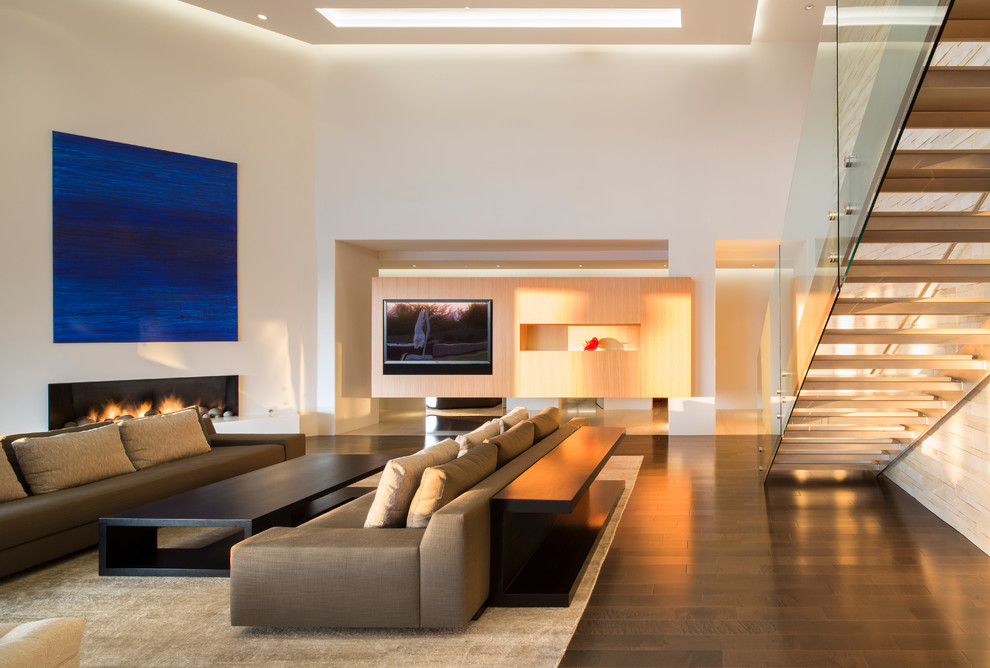 This is an example of a mid-sized contemporary formal open concept living room in Phoenix with white walls, dark hardwood floors, a ribbon fireplace, a plaster fireplace surround, a built-in media wall and brown floor.