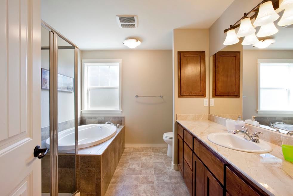 Large transitional master brown tile and ceramic tile porcelain tile drop-in bathtub photo with dark wood cabinets, marble countertops, shaker cabinets, beige walls and a drop-in sink