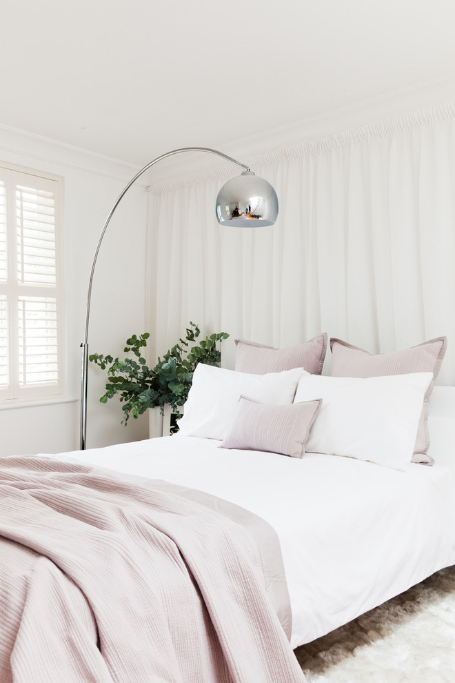 This is an example of a beach style bedroom in London with white walls.