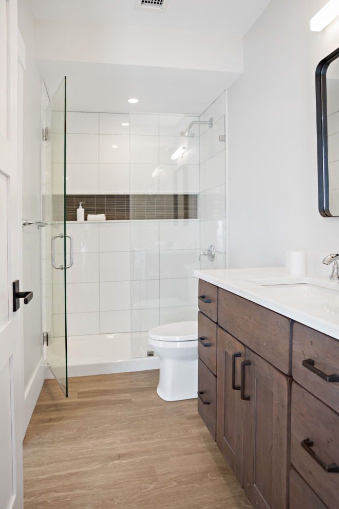Small contemporary 3/4 bathroom in Boston with shaker cabinets, brown cabinets, an alcove shower, a two-piece toilet, beige walls, vinyl floors, an undermount sink, quartzite benchtops, brown floor, a hinged shower door, white benchtops, a niche, a single vanity and a built-in vanity.